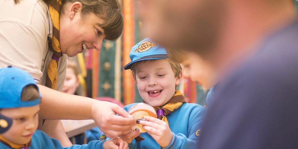 Adult helping Beavers with crafts